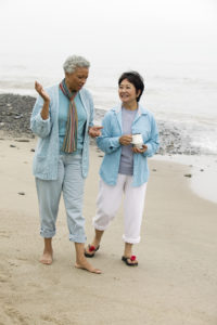 Two middle-aged women talking on beach
